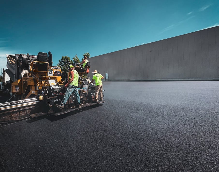 Industrial asphalt paving alongside a steel building