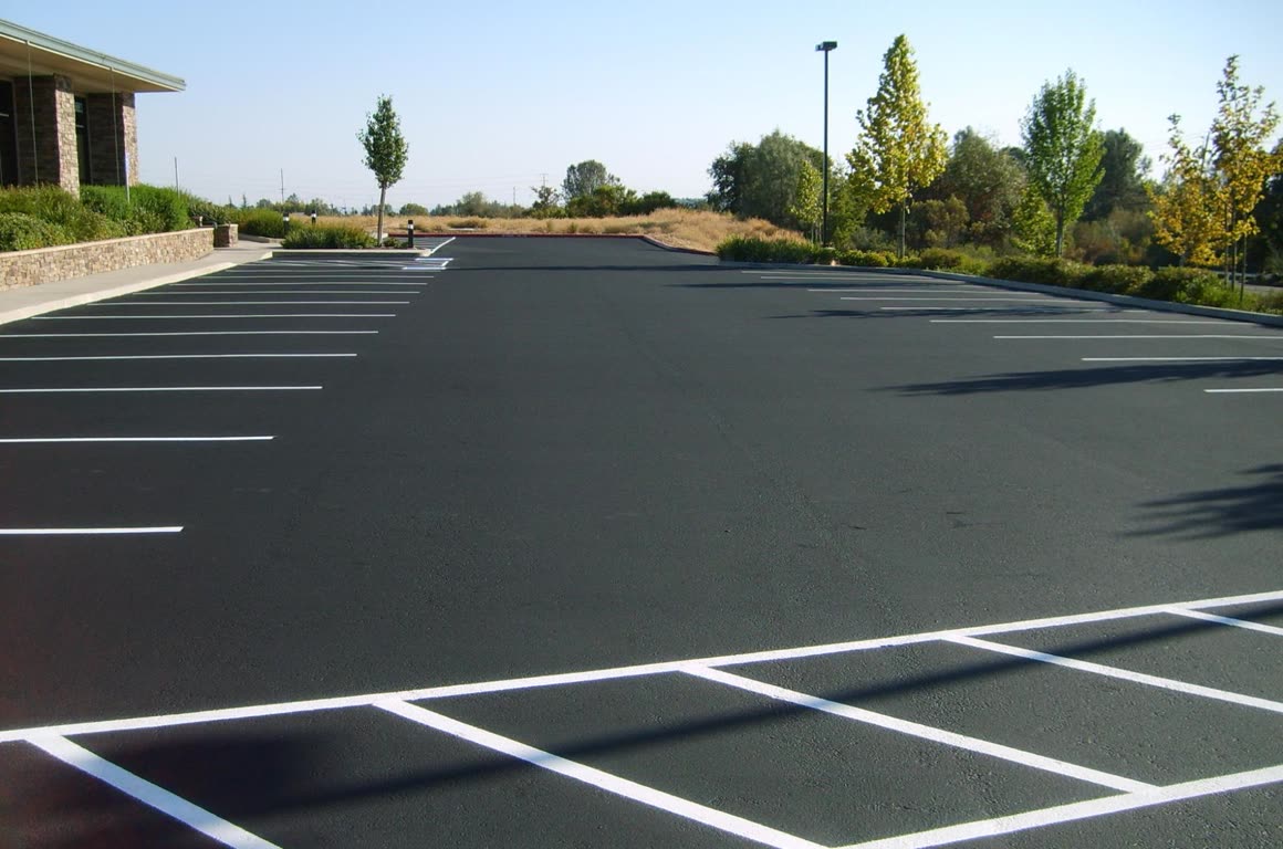 Freshly sealcoated commercial parking lot with crisp white striping